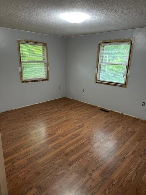 2073 Western Ave, Newburgh, ME 04444 - empty room featuring wood finished floors, plenty of natural light, and a textured ceiling