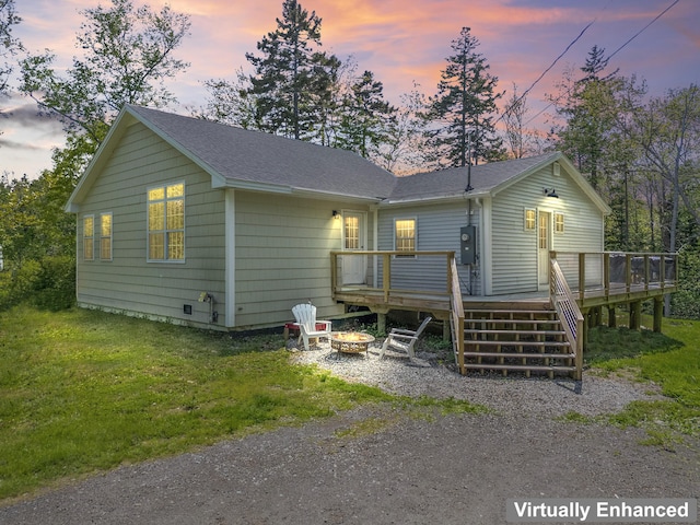 665 Hendricks Hill Rd, Southport, ME 04576 - view of front facade with an outdoor fire pit, a deck, a shingled roof, and a front lawn