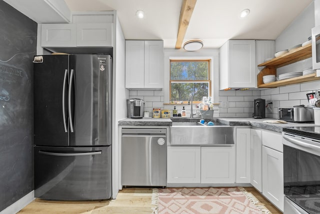 665 Hendricks Hill Rd, Southport, ME 04576 - kitchen with stainless steel appliances, decorative backsplash, white cabinets, open shelves, and light wood-type flooring
