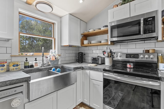 665 Hendricks Hill Rd, Southport, ME 04576 - kitchen featuring appliances with stainless steel finishes, vaulted ceiling, backsplash, white cabinetry, and open shelves