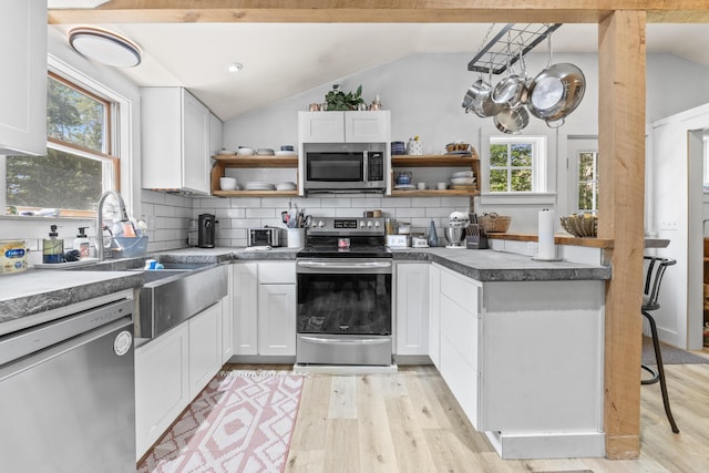 665 Hendricks Hill Rd, Southport, ME 04576 - kitchen featuring appliances with stainless steel finishes, open shelves, vaulted ceiling, plenty of natural light, and light wood-type flooring