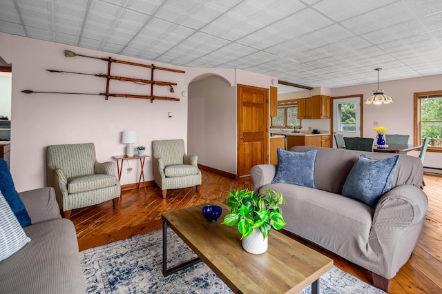94 Depot St, Waldoboro, ME 04572 - living area featuring light wood-style flooring, arched walkways, and a baseboard radiator
