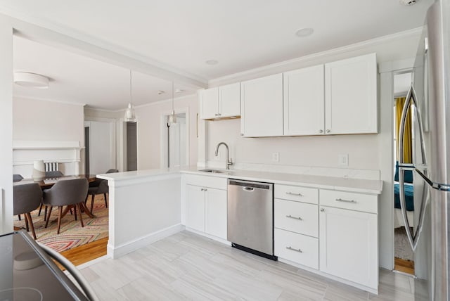 32 State St Unit 5, Portland, ME 04101 - kitchen featuring stainless steel appliances, light countertops, crown molding, white cabinetry, and hanging light fixtures
