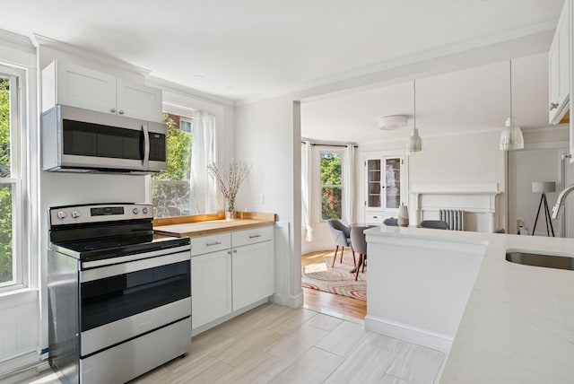 32 State St Unit 5, Portland, ME 04101 - kitchen with appliances with stainless steel finishes, white cabinetry, and hanging light fixtures