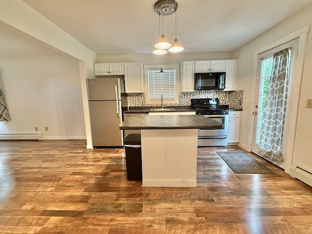 10 Turgeon St, Lewiston, ME 04240 - kitchen with freestanding refrigerator, black microwave, electric stove, dark countertops, and a baseboard radiator