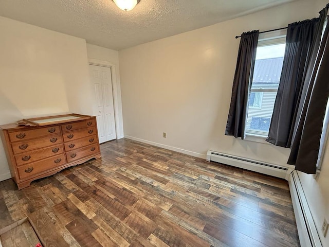 10 Turgeon St, Lewiston, ME 04240 - unfurnished bedroom featuring a baseboard radiator, dark wood-type flooring, a textured ceiling, and a closet