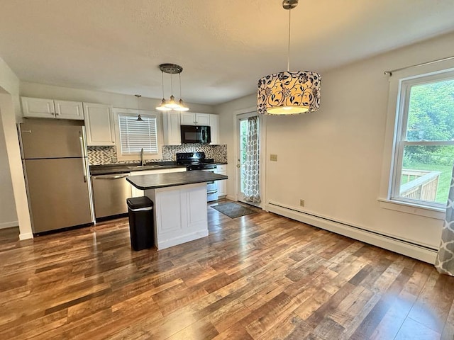 10 Turgeon St, Lewiston, ME 04240 - kitchen featuring appliances with stainless steel finishes, baseboard heating, dark countertops, white cabinetry, and dark wood finished floors