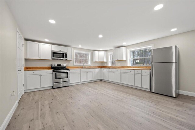 184 Jackson Rd, Waldoboro, ME 04572 - kitchen featuring appliances with stainless steel finishes, light wood-type flooring, white cabinets, recessed lighting, and light countertops