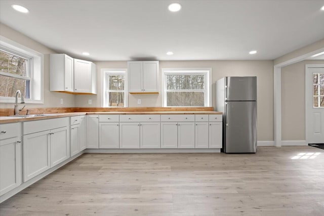 184 Jackson Rd, Waldoboro, ME 04572 - kitchen featuring freestanding refrigerator, plenty of natural light, white cabinets, light wood-style flooring, and recessed lighting