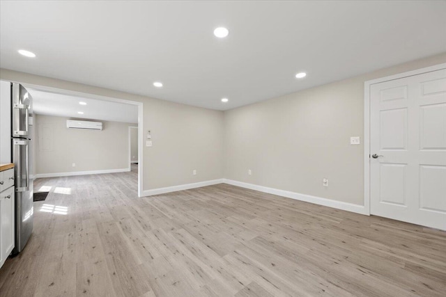 184 Jackson Rd, Waldoboro, ME 04572 - unfurnished living room with light wood-style flooring, a wall mounted air conditioner, and recessed lighting