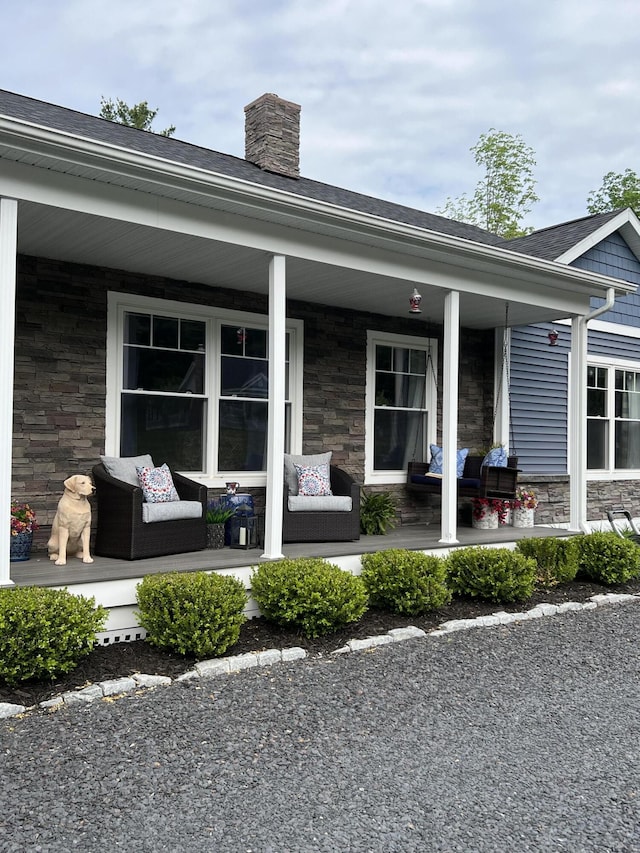 72 Cedar St, Calais, ME 04619 - view of exterior entry with a porch, stone siding, and a chimney