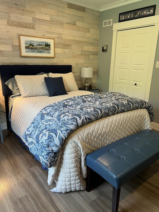 72 Cedar St, Calais, ME 04619 - bedroom with wooden walls, wood finished floors, ornamental molding, and a closet