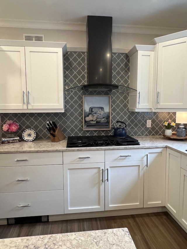 72 Cedar St, Calais, ME 04619 - kitchen featuring wall chimney exhaust hood, black gas cooktop, dark wood-type flooring, white cabinetry, and backsplash