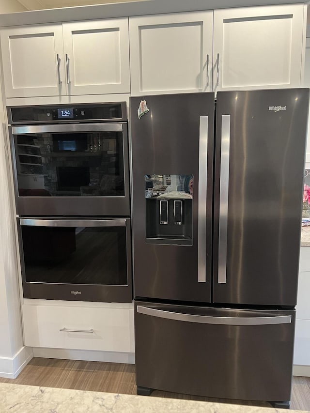 72 Cedar St, Calais, ME 04619 - kitchen with appliances with stainless steel finishes, light wood finished floors, and white cabinets