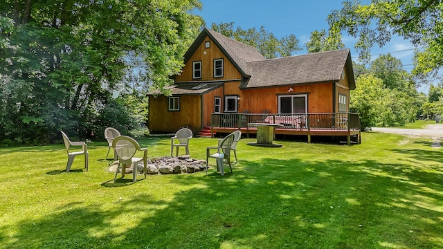 30 Troy Rd, Burnham, ME 04922 - rear view of house with a fire pit, a deck, a shingled roof, and a lawn