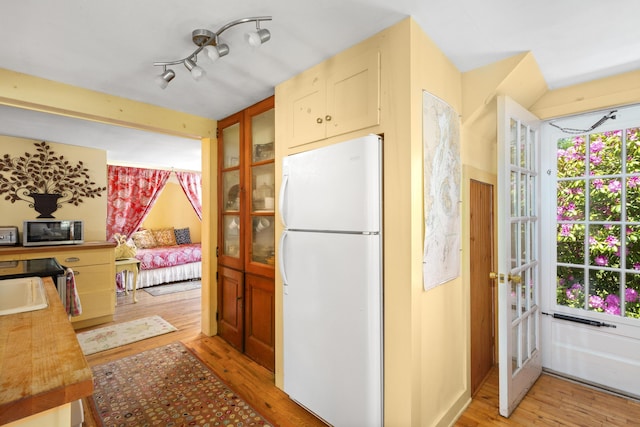 108 Colony Rd, Islesboro, ME 04848 - kitchen featuring freestanding refrigerator, stainless steel microwave, light wood-style floors, french doors, and healthy amount of natural light