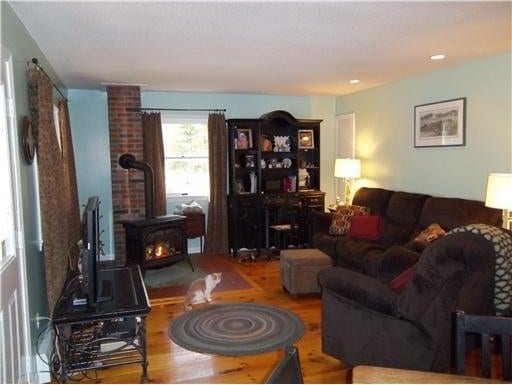 1 Weather Way, Dover-Foxcroft, ME 04426 - living room featuring wood finished floors and a wood stove