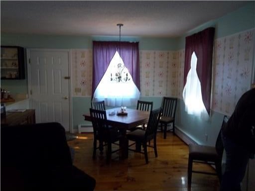 1 Weather Way, Dover-Foxcroft, ME 04426 - dining area with wallpapered walls, baseboard heating, and wood finished floors