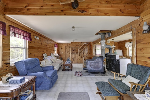 M18L1 Troutdale Rd, The Forks Plt, ME 04985 - living room with a wood stove, wooden walls, plenty of natural light, and tile patterned floors