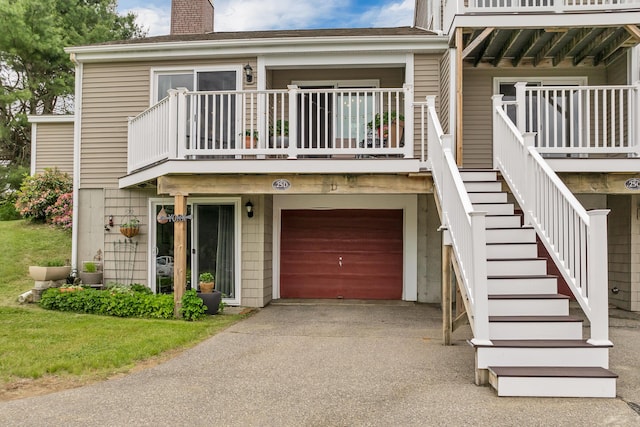 25 Riverview Dr Unit D, North Berwick, ME 03906 - view of front of property featuring a chimney, an attached garage, a balcony, and asphalt driveway