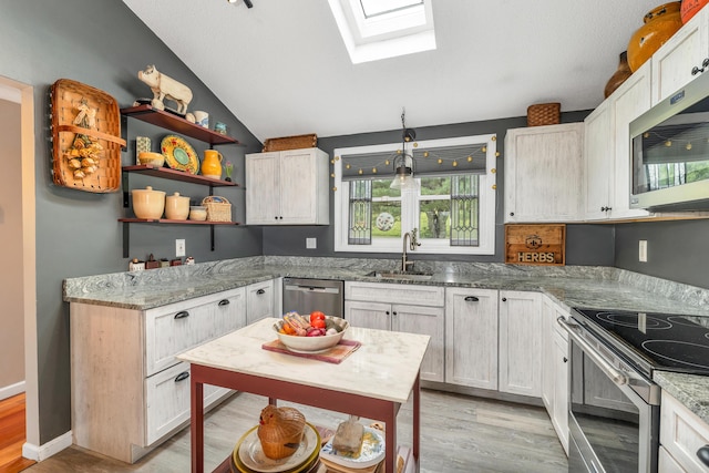 25 Riverview Dr Unit D, North Berwick, ME 03906 - kitchen featuring stainless steel appliances, a skylight, light wood-type flooring, vaulted ceiling, and light stone countertops