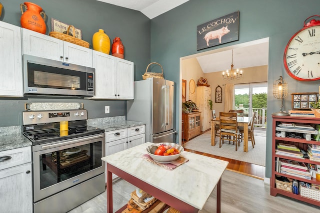 25 Riverview Dr Unit D, North Berwick, ME 03906 - kitchen with appliances with stainless steel finishes, light wood-style flooring, a chandelier, vaulted ceiling, and light stone counters