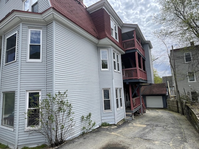 77 Maine Ave, Rumford, ME 04276 - view of side of home featuring driveway, an outdoor structure, a garage, and a balcony