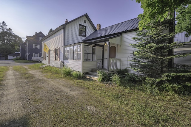 7 Hazen St, Norway, ME 04268 - view of front of home with a chimney, dirt driveway, and a metal roof