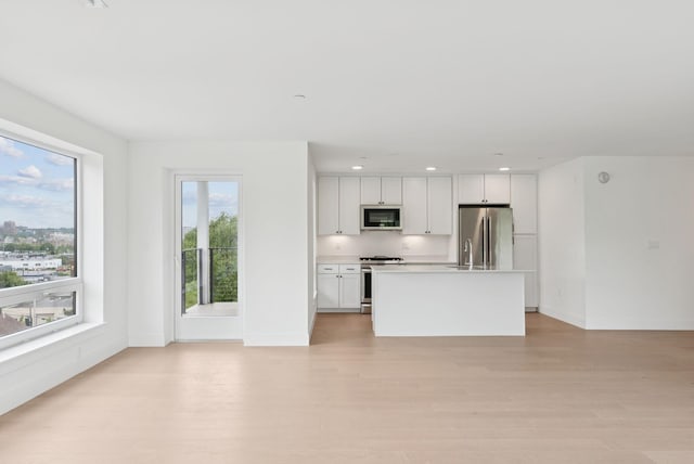 218 Washington Ave Unit 207, Portland, ME 04101 - kitchen with appliances with stainless steel finishes, light wood finished floors, light countertops, white cabinetry, and recessed lighting