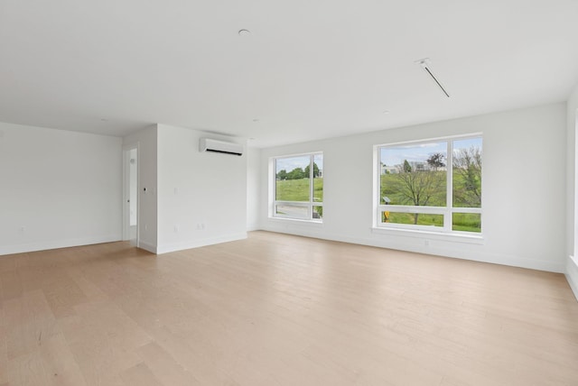 218 Washington Ave Unit 207, Portland, ME 04101 - unfurnished living room with an AC wall unit and light wood-type flooring