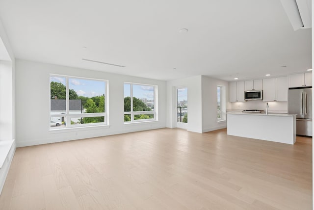 218 Washington Ave Unit 207, Portland, ME 04101 - unfurnished living room with light wood finished floors and recessed lighting