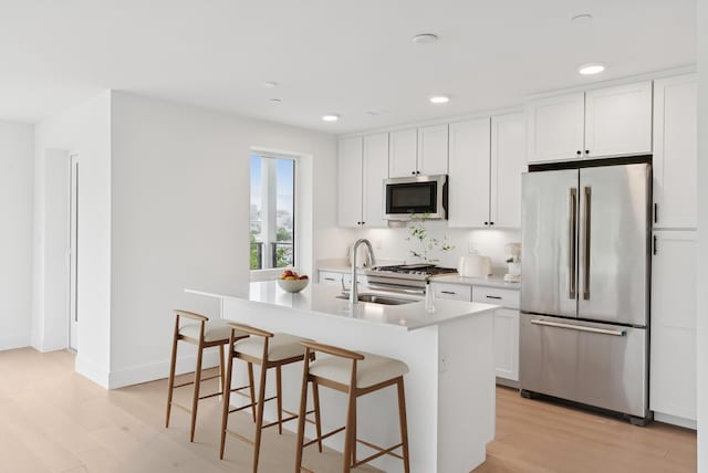 218 Washington Ave Unit 207, Portland, ME 04101 - kitchen with appliances with stainless steel finishes, light wood-style flooring, white cabinets, and recessed lighting