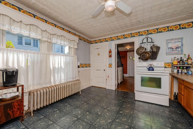 12 Court St, Rochester, NH 03867 - kitchen with white electric range, radiator, an ornate ceiling, ceiling fan, and brown cabinets