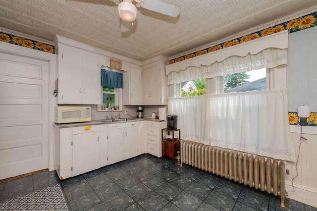12 Court St, Rochester, NH 03867 - kitchen featuring radiator, white microwave, white cabinets, light countertops, and ceiling fan