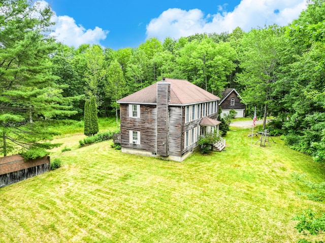 15 Loon Call Dr, Belgrade, ME 04917 - view of side of home featuring a yard, a chimney, a wooded view, and roof with shingles