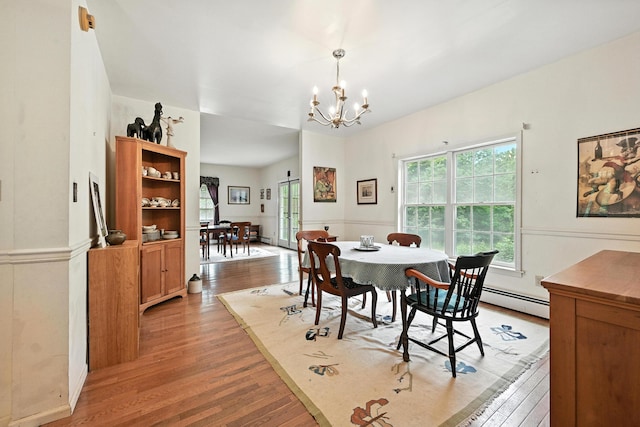 15 Loon Call Dr, Belgrade, ME 04917 - dining area with light wood-style flooring, a chandelier, plenty of natural light, a baseboard heating unit, and a wainscoted wall