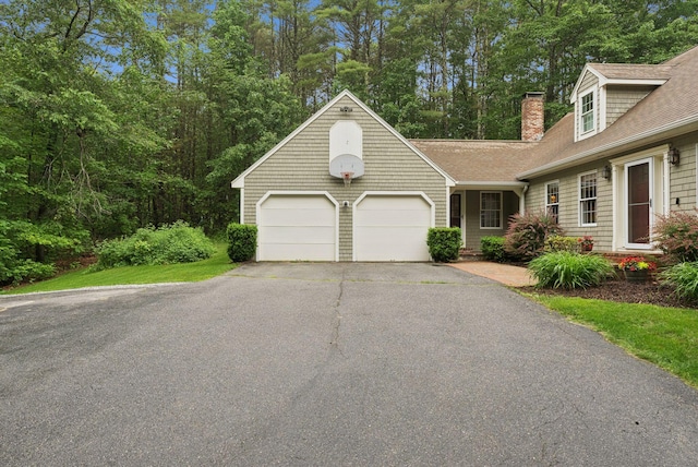 3 Flintlock Ln, Falmouth, ME 04105 - view of front facade with a shingled roof, asphalt driveway, an attached garage, and a chimney