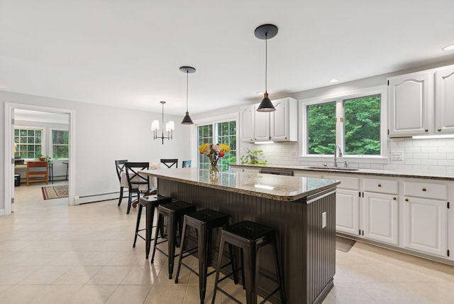 3 Flintlock Ln, Falmouth, ME 04105 - kitchen with light stone countertops, decorative backsplash, light tile patterned flooring, a baseboard radiator, and recessed lighting