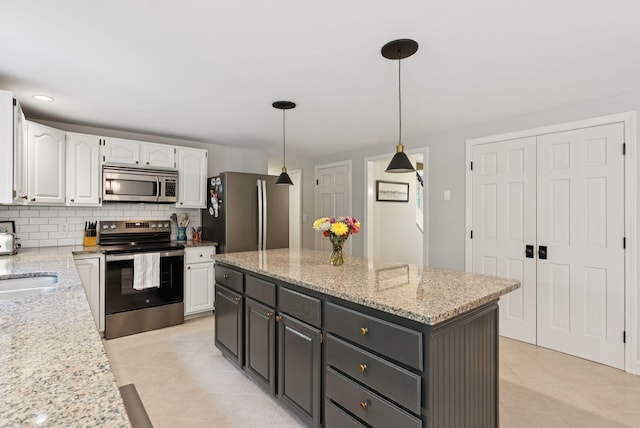 3 Flintlock Ln, Falmouth, ME 04105 - kitchen with stainless steel appliances, white cabinetry, light tile patterned flooring, and tasteful backsplash