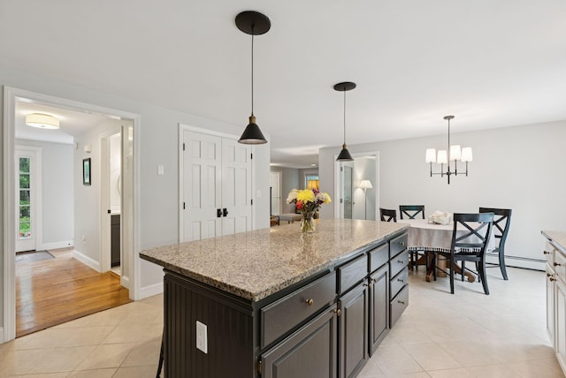 3 Flintlock Ln, Falmouth, ME 04105 - kitchen featuring light tile patterned floors, a center island, decorative light fixtures, light stone countertops, and a chandelier