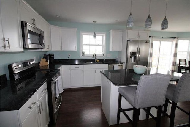 905 Blackstream Rd, Hermon, ME 04401 - kitchen featuring appliances with stainless steel finishes, a breakfast bar, white cabinets, dark wood-style floors, and pendant lighting