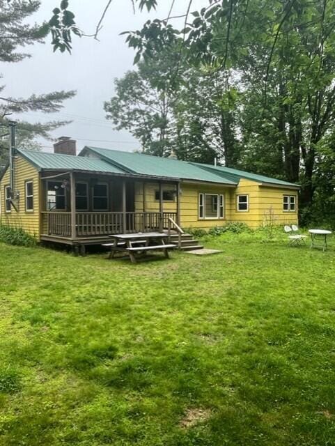 22 Lamb Farm Rd, Brunswick, ME 04011 - back of property featuring a chimney, a lawn, a wooden deck, and a metal roof