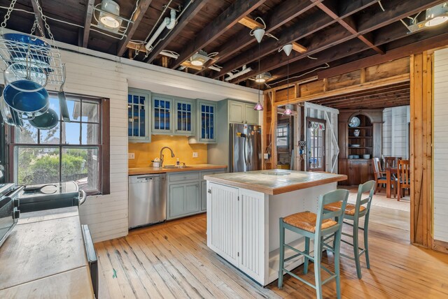 6 Fort Hill Ave, York, ME 03909 - kitchen with stainless steel appliances, wooden walls, light wood-style flooring, light countertops, and a center island