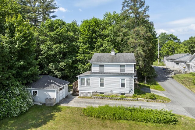 8 Riverview Ave, Lewiston, ME 04240 - rear view of property with a garage, an outbuilding, a chimney, a shingled roof, and a yard