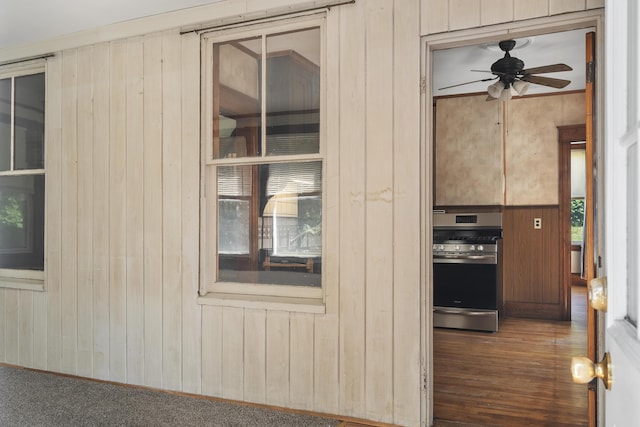 8 Riverview Ave, Lewiston, ME 04240 - detailed view of gas range, wooden walls, ceiling fan, and wood finished floors