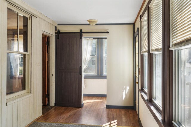 8 Riverview Ave, Lewiston, ME 04240 - unfurnished bedroom with dark wood-style flooring, a barn door, and crown molding