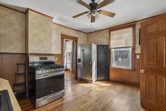 8 Riverview Ave, Lewiston, ME 04240 - kitchen featuring stainless steel appliances, light wood finished floors, ceiling fan, ornamental molding, and wainscoting