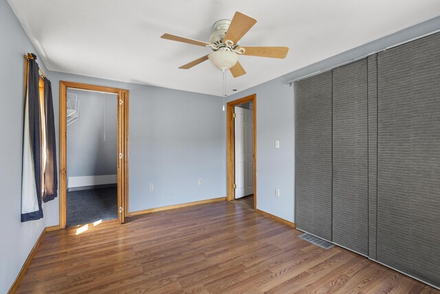 8 Riverview Ave, Lewiston, ME 04240 - unfurnished bedroom with wood finished floors, a ceiling fan, a spacious closet, and a closet