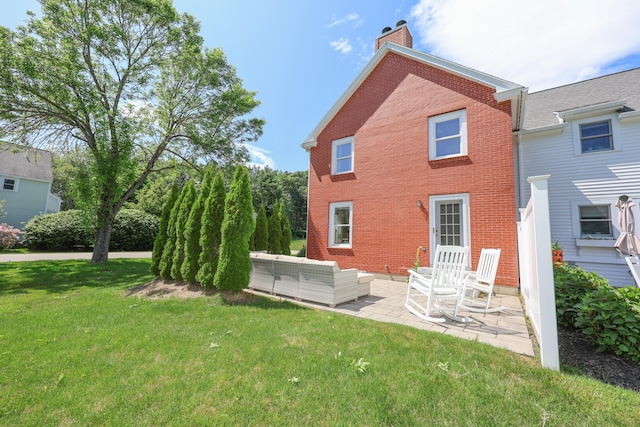 1 Ephraim Tyler Way Unit 1, Kennebunk, ME 04043 - rear view of house with a chimney, a patio area, outdoor lounge area, brick siding, and a lawn