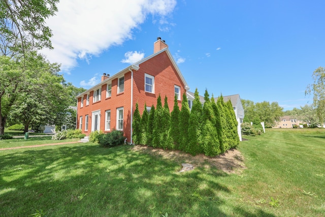 1 Ephraim Tyler Way Unit 1, Kennebunk, ME 04043 - view of side of home with a chimney, brick siding, and a yard